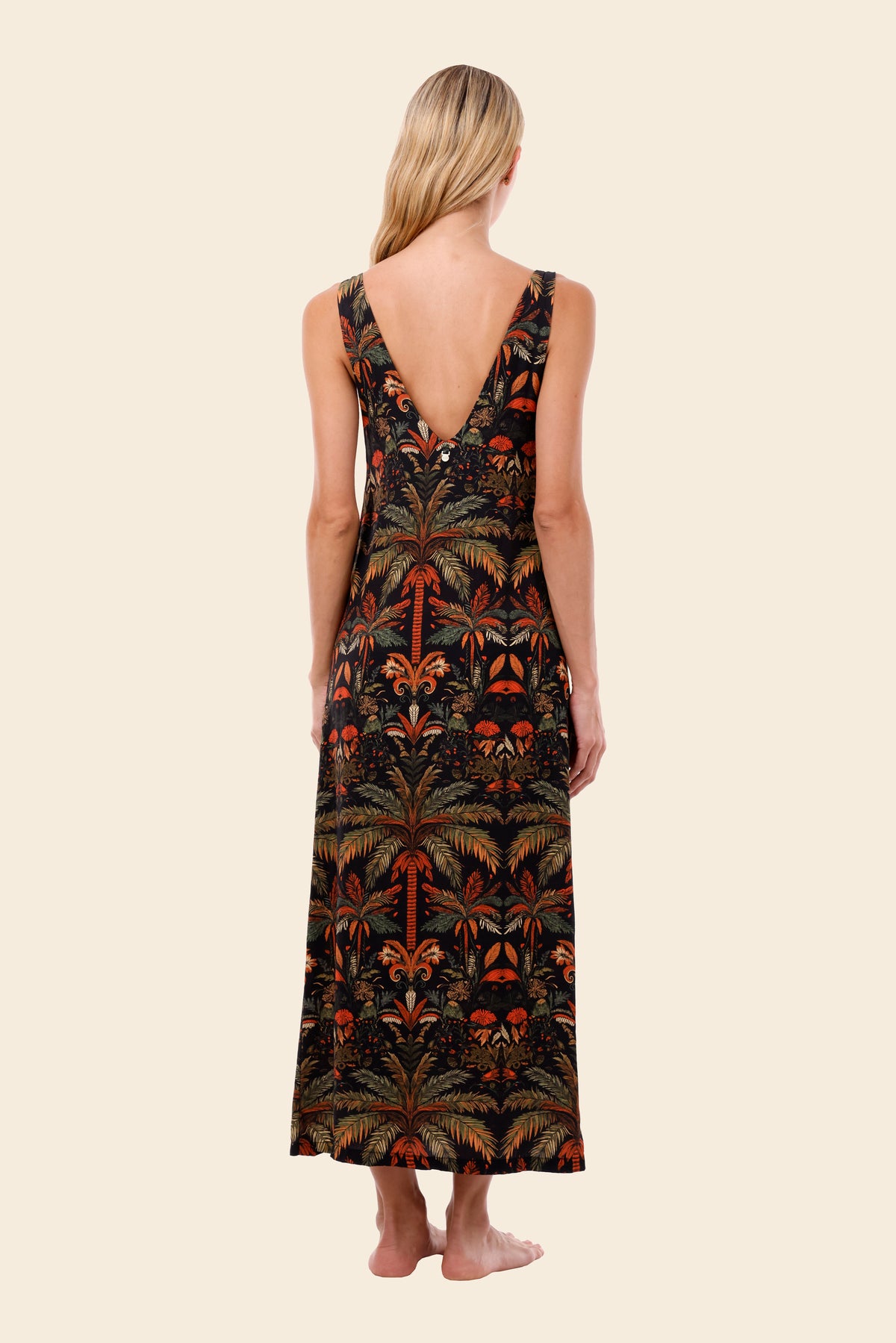 Woman wearing a tropical patterned dress on a beige background