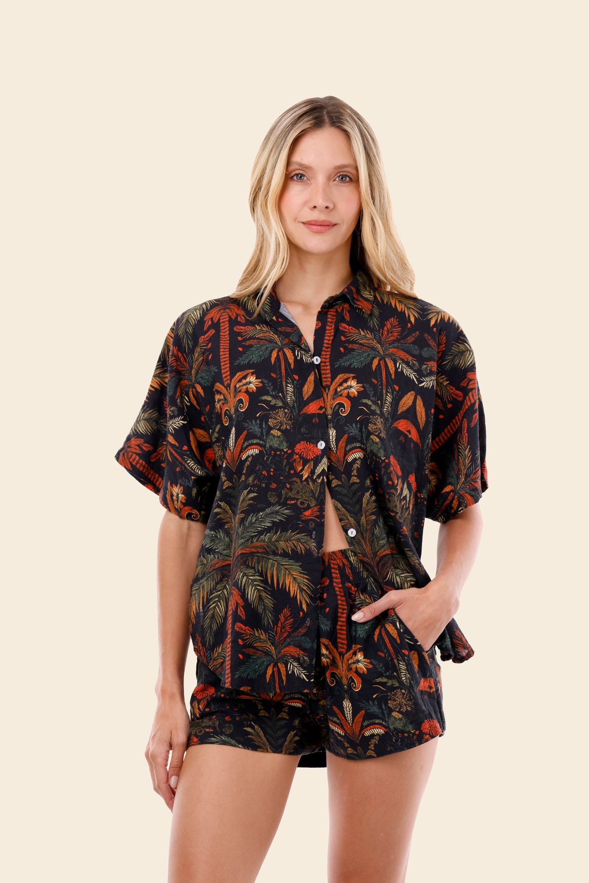 Woman wearing a patterned shirt and shorts set on a beige background, resort wear for women