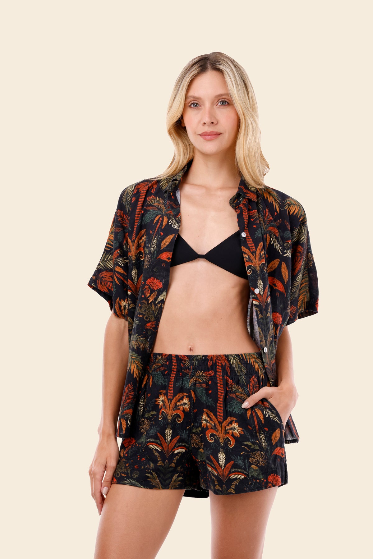 Woman wearing a patterned jacket and shorts set on a beige background