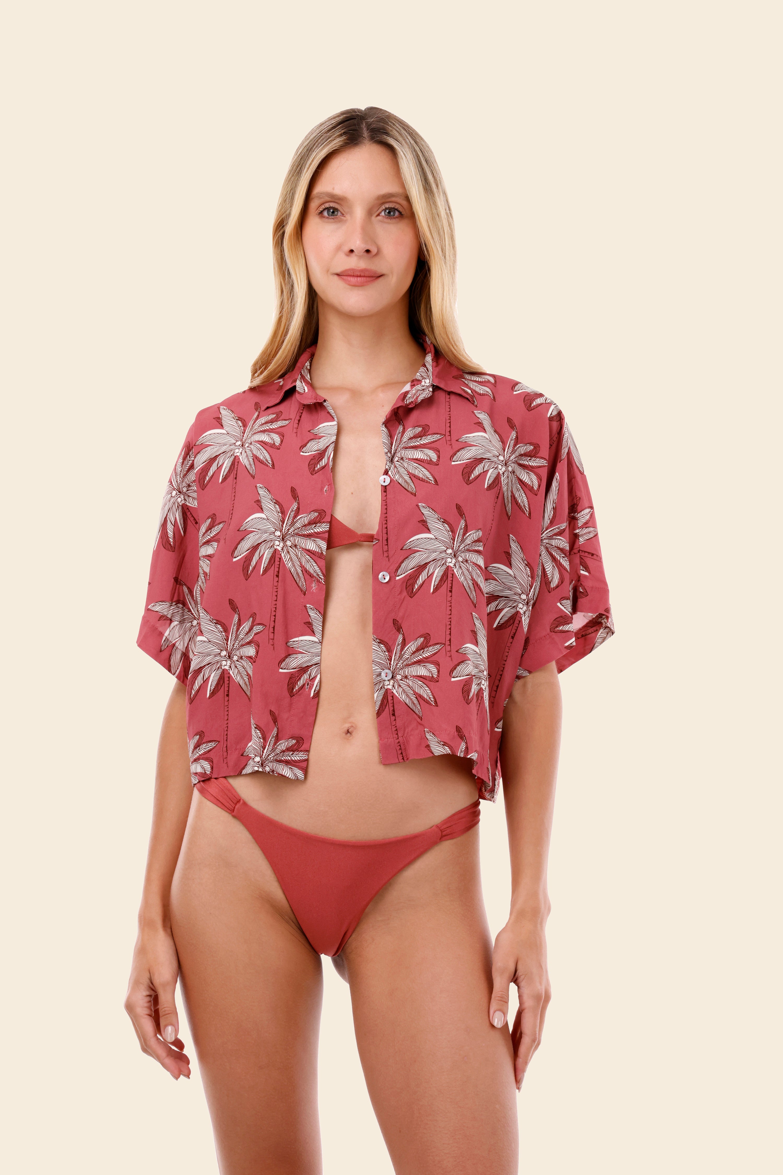 Woman wearing a red palm tree patterned shirt over a bikini