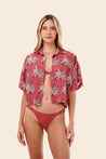 Woman wearing a red palm tree patterned shirt over a bikini