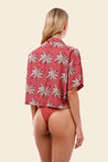 Woman wearing a red floral shirt and matching bottoms 