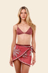Woman wearing a maroon bikini top and matching flower pareo