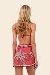 Woman wearing a maroon bikini top and matching flower pareo